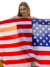 Monika May Frolics Naked In Meadows Waving Flag And Teasing With Playful Poses