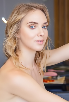 Oxana Z. teases in a pink apron kitchen solo spread showing nude poses and smiling curves